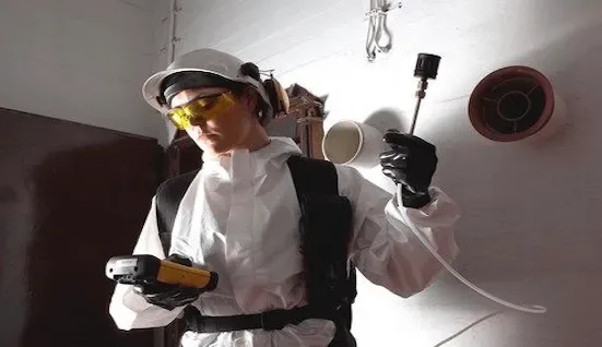 Indoor air quality testing technician with respirator
